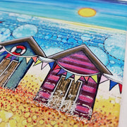 Close-up of Beach Hut and Bunting ceramic trivet showing colourful beach huts with bunting and life ring beside bubble-effect sea