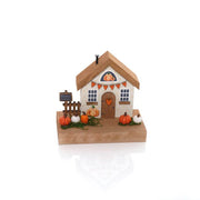 Pumpkin Cottage wooden house ornament with miniature pumpkins, orange bunting, small fence and Pumpkin Cottage sign on a natural wood base, white background