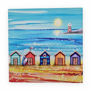 5 Beach Huts and Lighthouse ceramic trivet flat lay on white background showing full design with five colourful beach huts, surfboard, life ring, red flag and lighthouse with sparkling textured sea