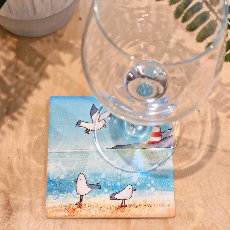 Seagull and Lighthouse ceramic coaster with wine glass showing coastal scene with seagulls and lighthouse