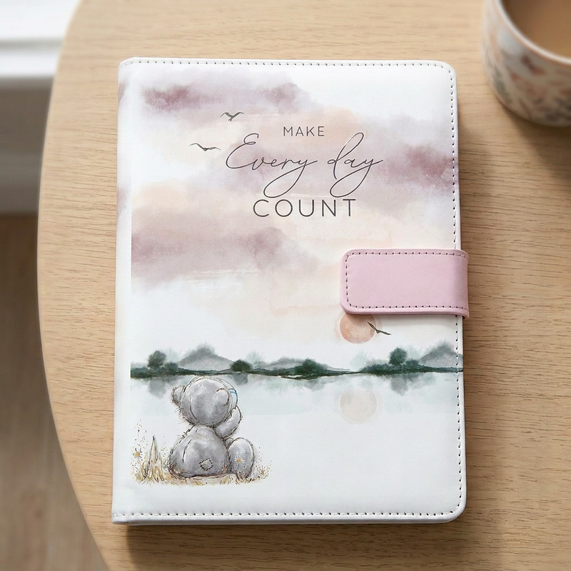 Tatty Teddy “Make Every Day Count” journal lying on a light wood desk in soft natural daylight.