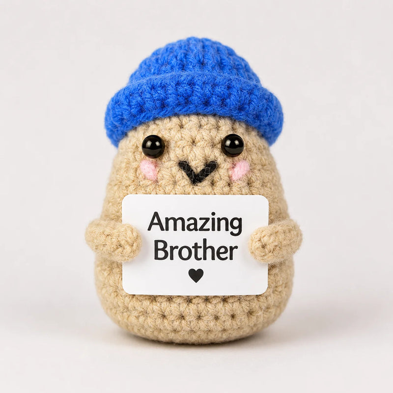 Amazing Brother Positive Crochet Gift character wearing a bright blue beanie hat and holding an Amazing Brother sign, presented on a white background