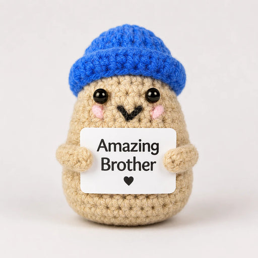 Amazing Brother Positive Crochet Gift character wearing a bright blue beanie hat and holding an Amazing Brother sign, presented on a white background