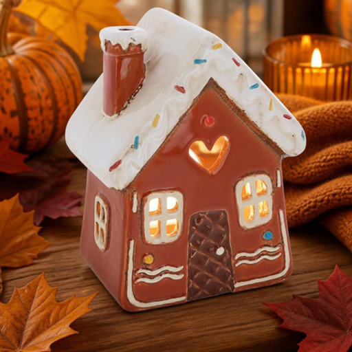 Village Pottery gingerbread house tealight holder with snow-dusted roof, sprinkle details, waffle-pattern door, heart cut-out and wavy icing trim