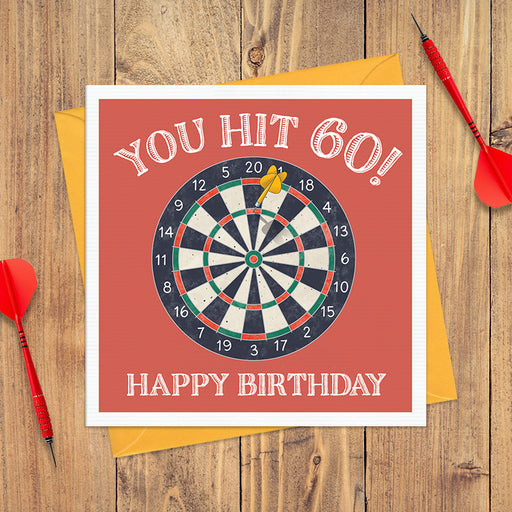 60th birthday card with a dartboard on a red background with a single yellow dart and the text "You Hit 60! Happy Birthday"