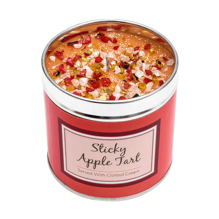 Sticky Apple Tart scented candle in a tin with sparkly topping, label reading "Sticky Apple Tart Served With Clotted Cream", white background