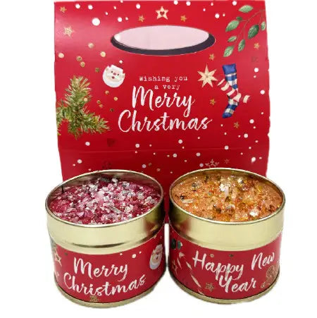 Merry Christmas and Happy New Year candle tin duo gift set — two fragranced tins with sparkly toppings, presented in a festive red gift bag