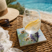 Bumblebee and Lavender ceramic coaster on wicker tray with gin and tonic glass, straw hat and sunglasses, seaside setting