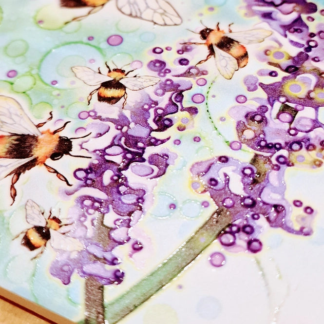 Close-up of Bumblebee and Lavender ceramic coaster showing embossed bumblebee and lavender detail with teal bubble-effect background