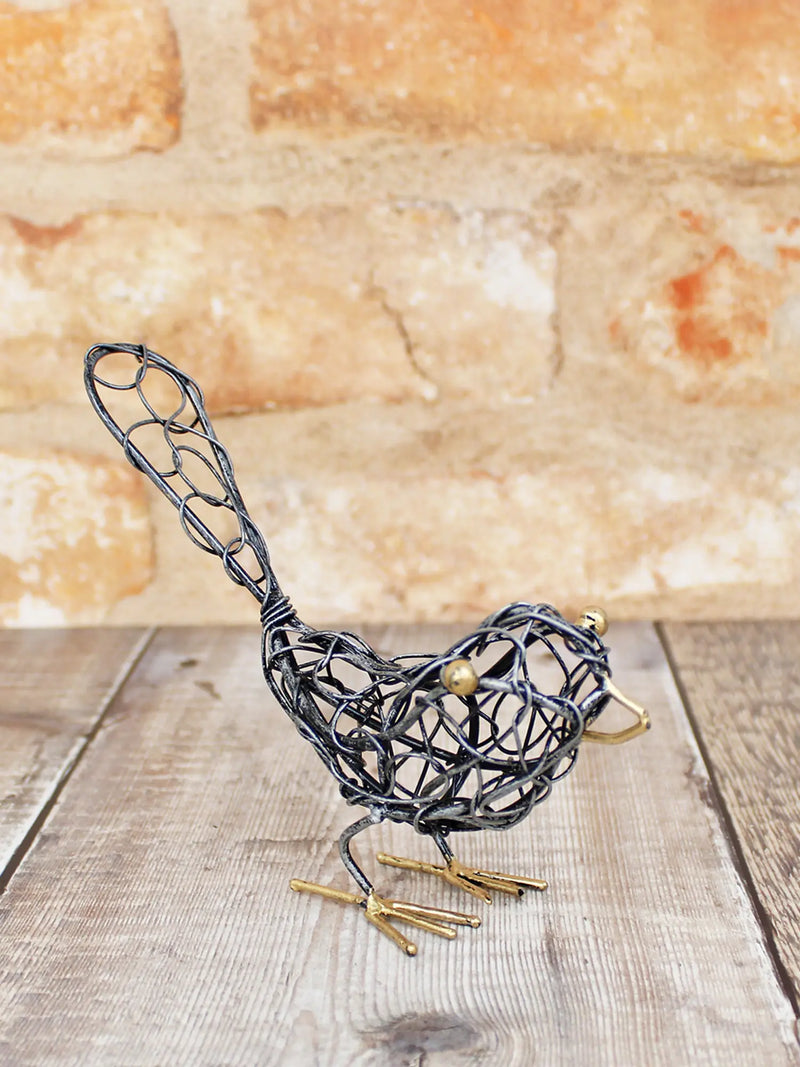 Open ironwork bird ornament handmade in Bali, twisted and looped wire body with looped wire tail, gold-coloured eyes, beak and feet, 12cm tall