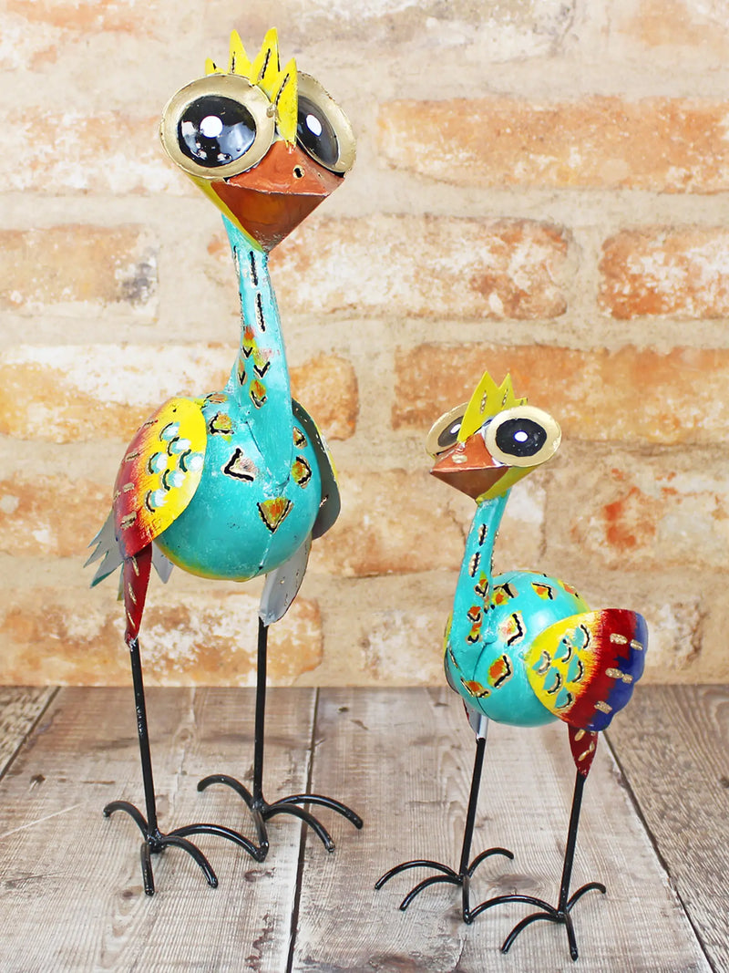 Small and large hand-painted big-eye metal bird ornaments handmade in Bali, vivid bold tones with oversized googly eyes, yellow crowns, patterned bodies and curly wire feet