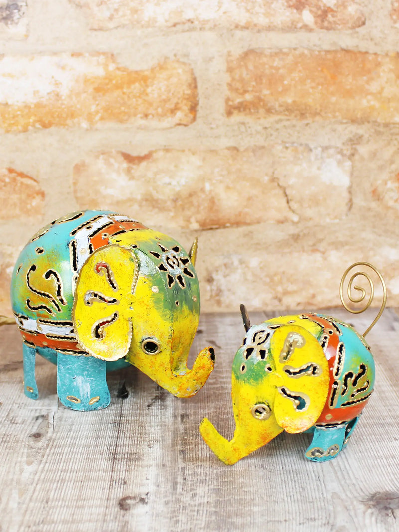 Small and large colourful hand-painted metal elephant ornaments handmade in Bali, vivid mix of warm and cool tones with intricate cut-out patterns