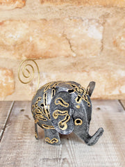 Dark metal elephant ornament small 8cm, handmade in Bali, intricate gold-coloured cut-out pattern detail, curly gold-coloured wire tail and upturned trunk