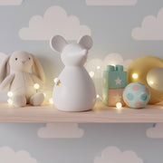 Large ceramic standing mouse in white on a bedroom shelf