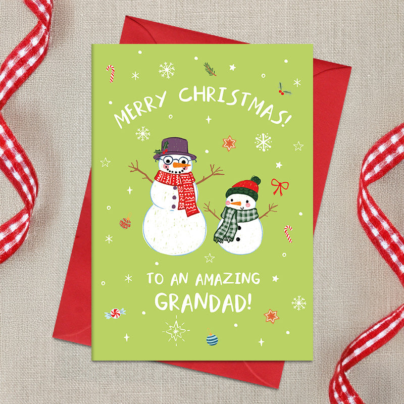Amazing Grandad Christmas card featuring two illustrated snowmen in cosy scarves and hats, surrounded by snowflakes and festive decorations, with a Merry Christmas greeting