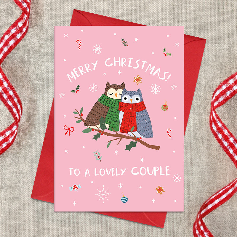 Lovely Couple Christmas card featuring two illustrated owls in cosy scarves perched together on a branch, surrounded by snowflakes and festive details, with a Merry Christmas greeting