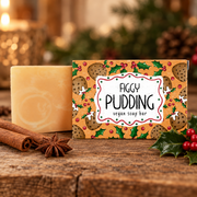 Neon Magpie Figgy Pudding Vegan Soap Bar in festive orange packaging styled on a rustic wooden surface with cinnamon sticks, star anise and holly