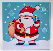 Ceramic Christmas coaster featuring Father Christmas carrying a sack and holding a wrapped present, surrounded by snowflakes and falling snow.