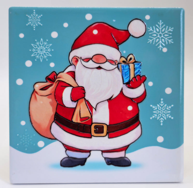Ceramic Christmas coaster featuring Father Christmas carrying a sack and holding a wrapped present, surrounded by snowflakes and falling snow.