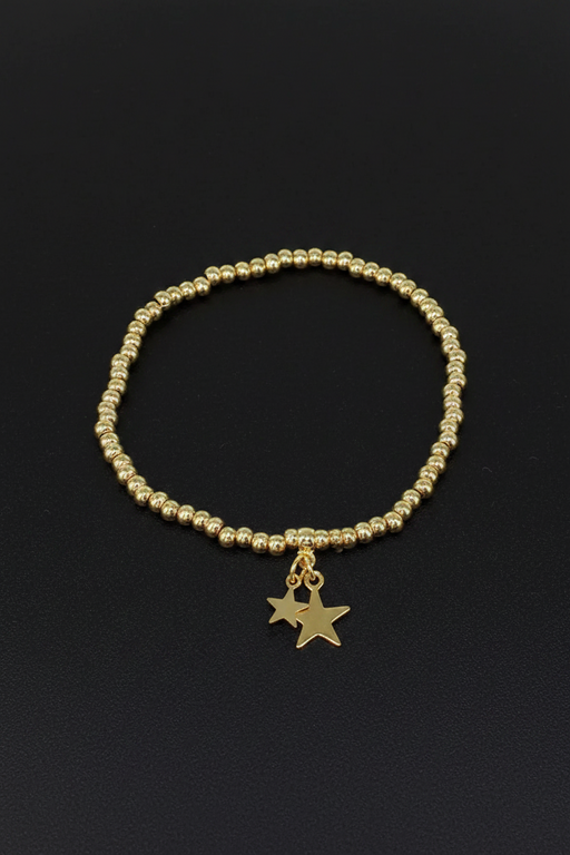 18ct gold plated elasticated round bead bracelet with two dangling star charms on a black background