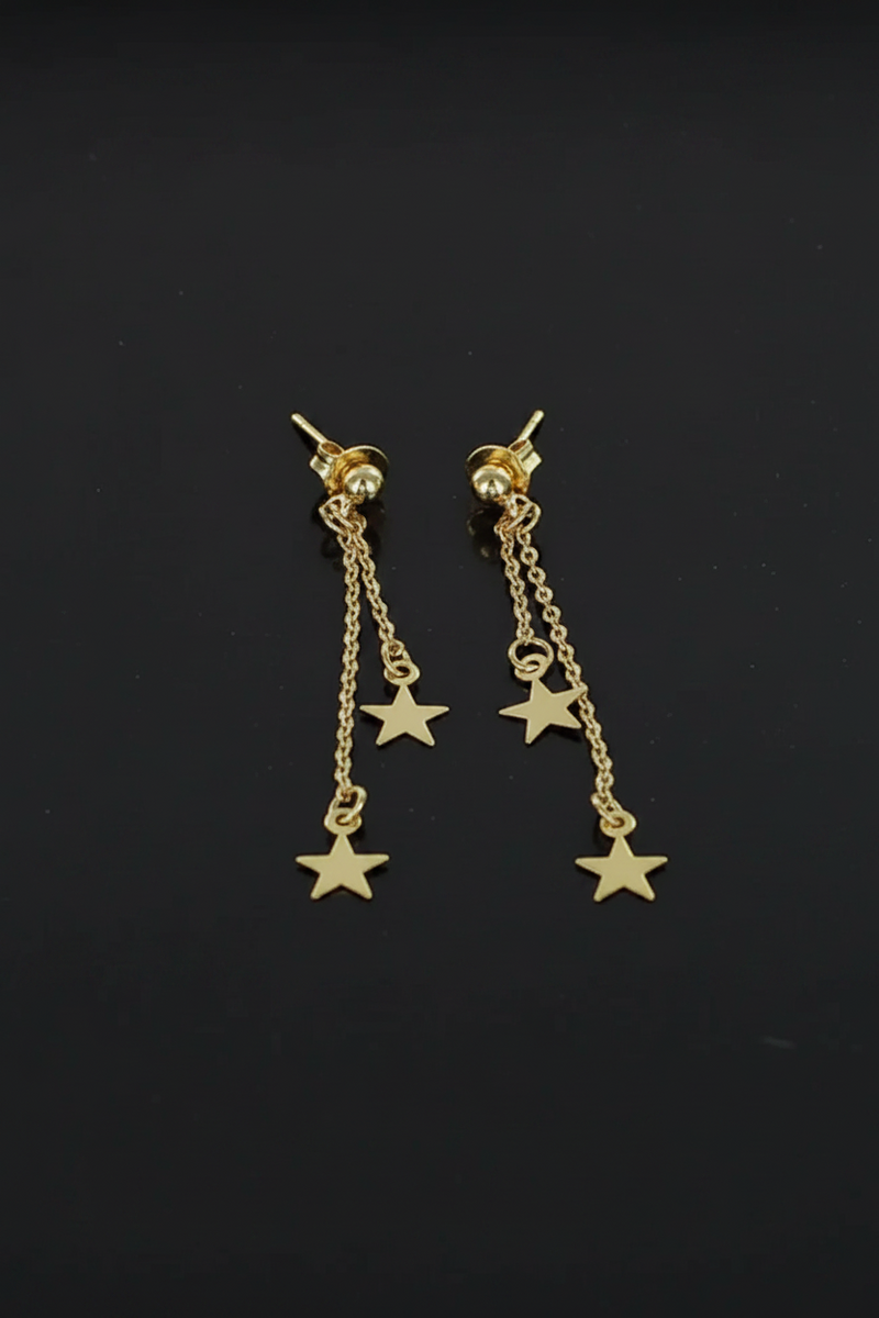 Gold plated double drop star charm stud earrings with fine chain drops on a black background