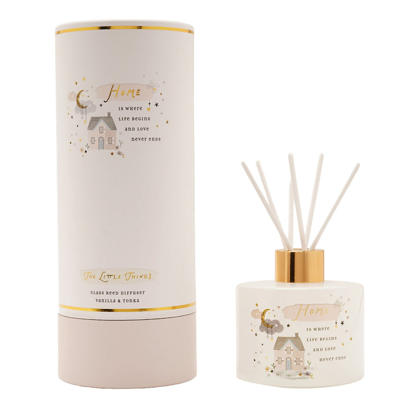 The Little Things Home glass reed diffuser with white reeds and gold collar next to white cylindrical gift box on white background, vanilla and tonka fragrance