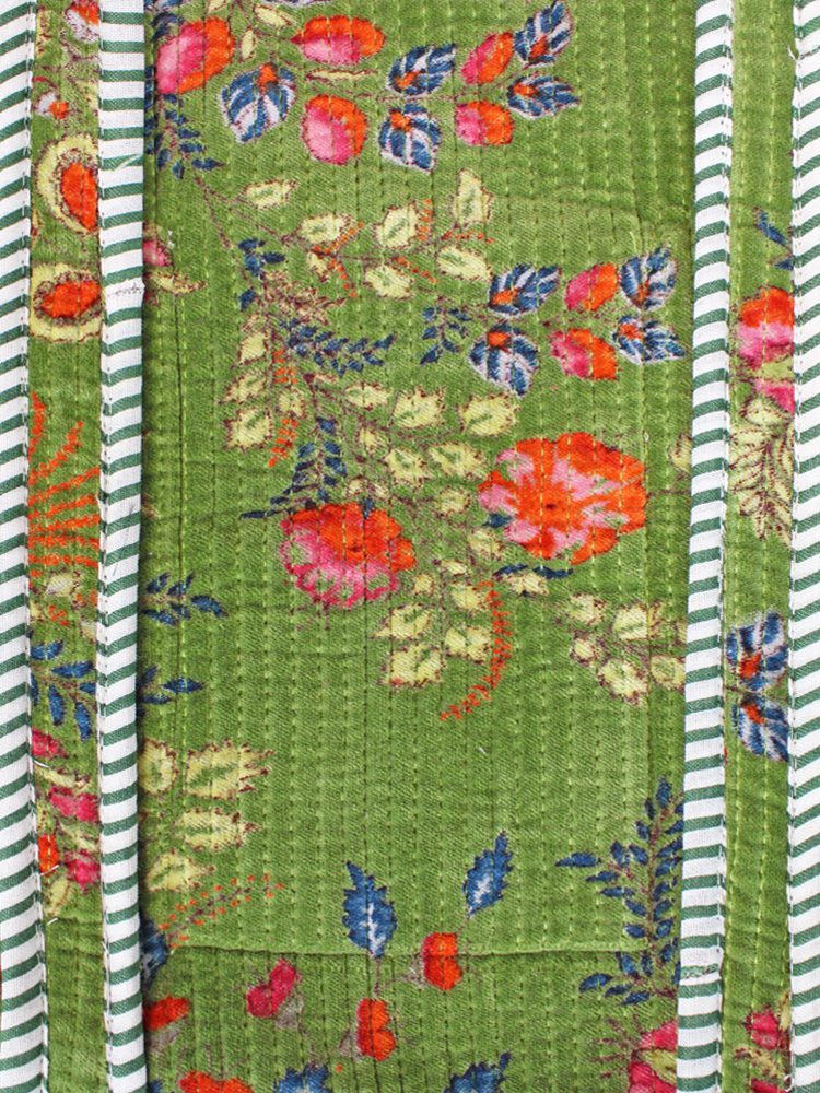 Close-up of quilted velvet floral fabric with striped trim detail on tote bag