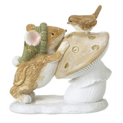 A decorative figurine of a mouse wearing a green hat leaning against a toadstool with a small bird perched on top, on a white background