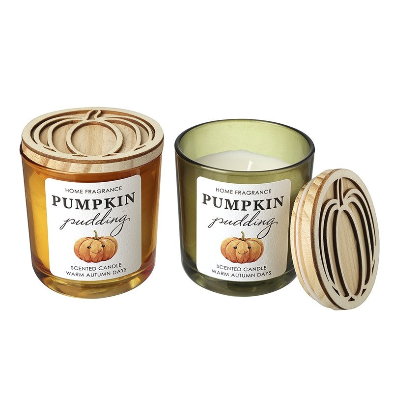 Pumpkin Pudding Scented Candle shown in both colourways — amber orange glass jar with lid on (left) and sage green glass jar with lid off (right) — both with laser-cut wooden pumpkin lids, on a white background