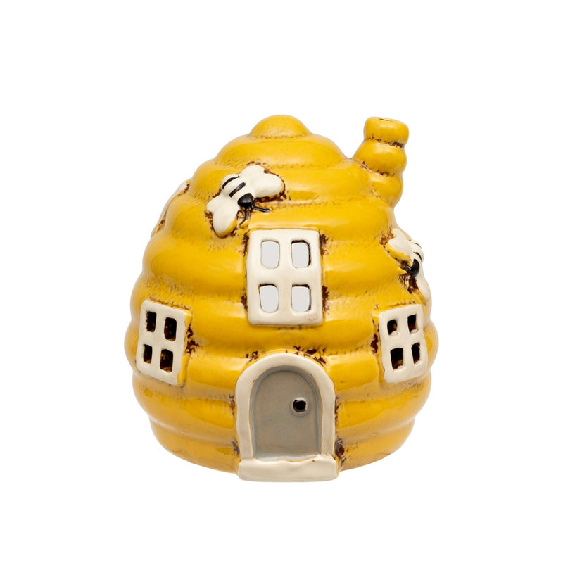 Beehive Cottage Tealight Holder golden yellow ceramic beehive-shaped tealight holder with ridged coils white-framed windows arched grey door chimney and bees on the sides on white background
