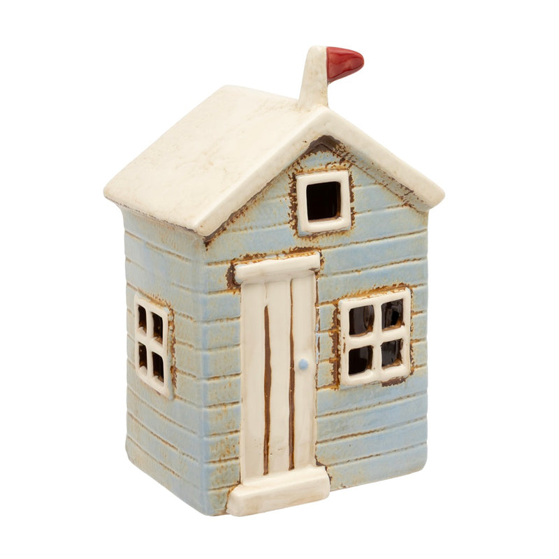 Ceramic beach hut tealight holder with clapboard walls, cut-out windows, front door and flag detail on chimney