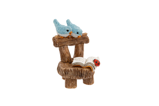 Blue Birds on Chair Ornament polyresin figurine of two blue birds perched on the back of a rustic log chair with an open book and ladybird on the seat on white background