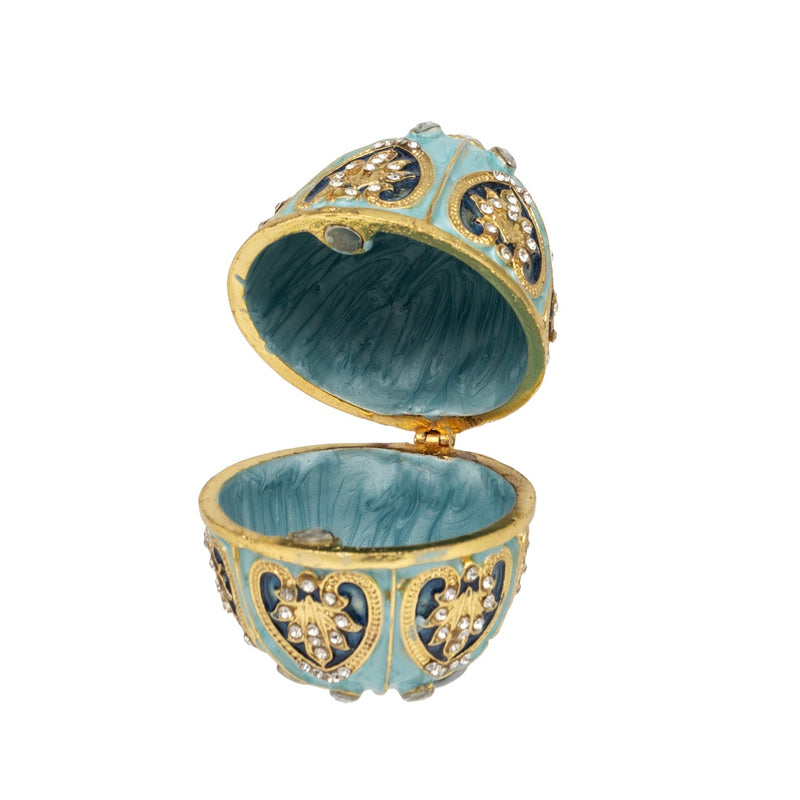 Turquesa Egg Trinket Box open, showing turquoise interior and hinged lid with gold-tone detailing and crystal-effect stone panels, on white background