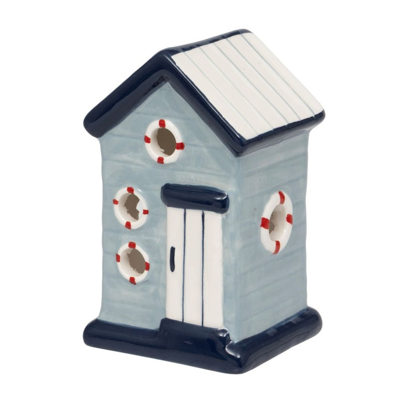 Beach Hut LED Ornament, pale blue ceramic beach hut with navy roof and base, white panelled door, circular porthole openings with life ring details, warm LED glow, on white background