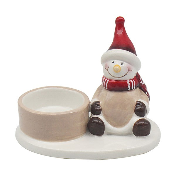 Snowman Christmas tealight holder with red hat and red and white striped scarf, sitting beside a single tealight holder on an oval base, white background