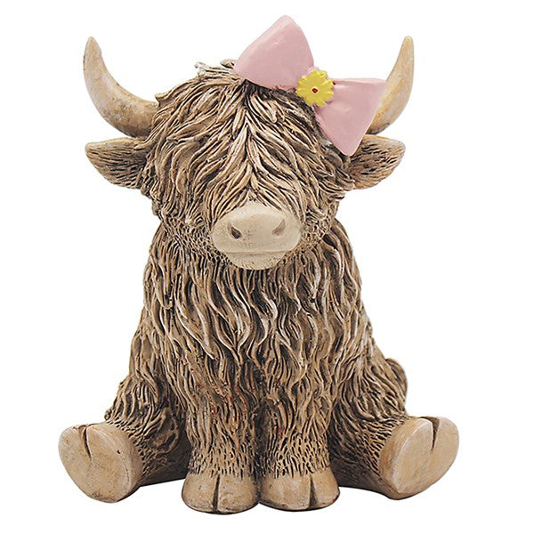Highland Cow figurine with pink bow and yellow flower, shaggy brown coat, seated position, on white background