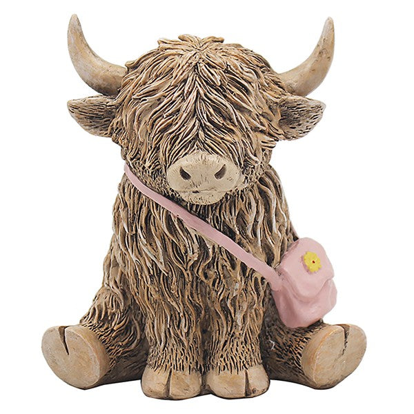 Highland cow figurine with pink floral handbag slung over shoulder, sitting pose with shaggy fur detail and curved horns, on a white background


