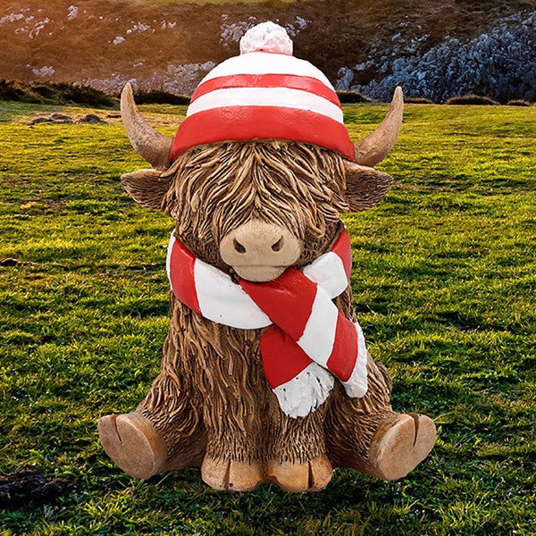 Ceramic Happy Highland Cow figurine wearing a red and white striped hat and scarf, from the Leonardo Happy Highland Cow collection, presented in a gift box