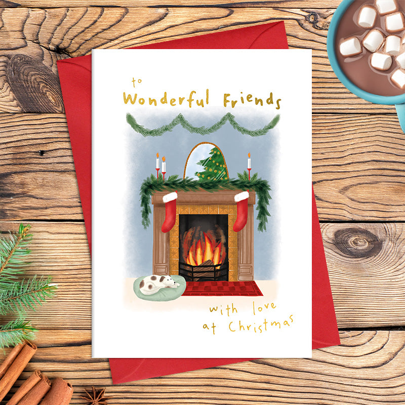 Wonderful Friends Christmas card featuring a cosy fireplace with stockings, greenery and candles, a dog resting beside the hearth and the message ‘With love at Christmas