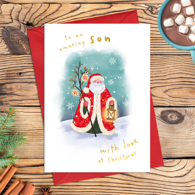 Amazing Son Christmas card featuring illustrated Father Christmas holding a lantern among snowflakes, with the message ‘With love at Christmas