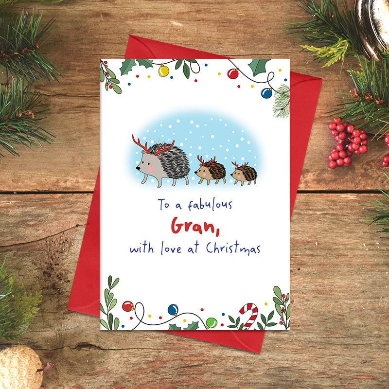 Fabulous Gran Christmas card featuring three illustrated hedgehogs wearing festive antlers, with the message ‘With love at Christmas’ and a festive foliage border.