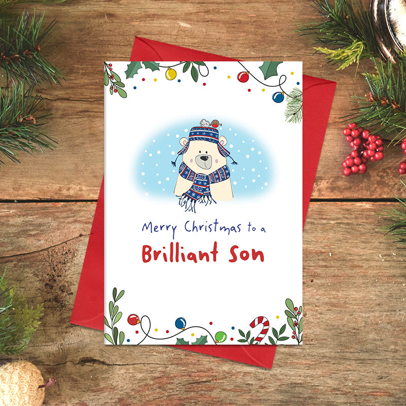 Brilliant Son Merry Christmas card featuring an illustrated polar bear in a patterned scarf and earflap hat, with a little robin perched on the hat and festive foliage around the border.