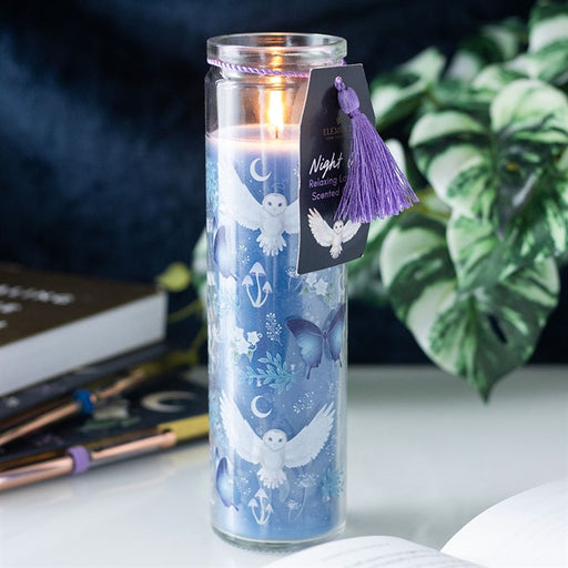 Night Owl Lavender tube candle in glass jar with purple tassel and gift tag, lit and styled on a white surface with a plant and notebook in the background