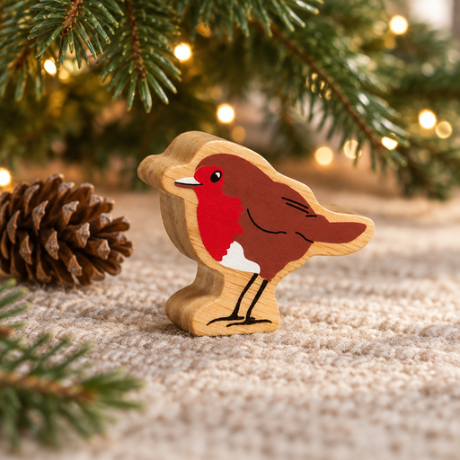 Wooden robin toy beneath Christmas tree branches beside a pinecone and warm fairy lights