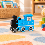 Wooden train counting jigsaw numbered 1–5 on a play mat beside building blocks, with a book basket softly blurred behind