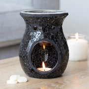 Large black crackle oil burner and wax warmer styled in a home setting, casting a warm atmospheric glow
