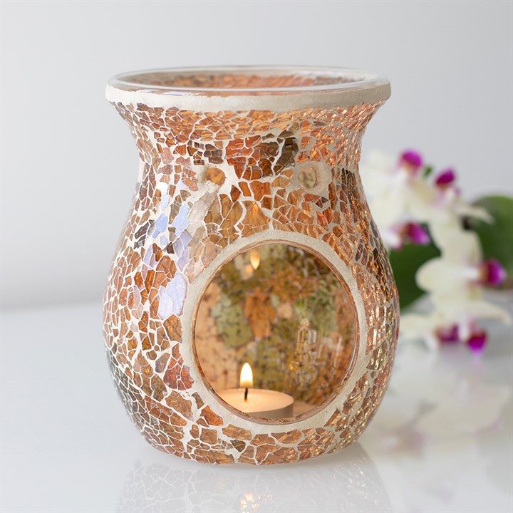 Large brown crackle oil burner and wax warmer styled in a home setting, radiating a warm golden glow