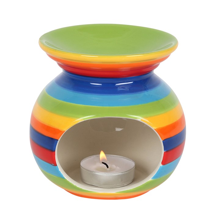 Rainbow Stripe Oil Burner, front view showing round ceramic body with bold rainbow stripes and oval tealight cut-out with lit tealight, white background