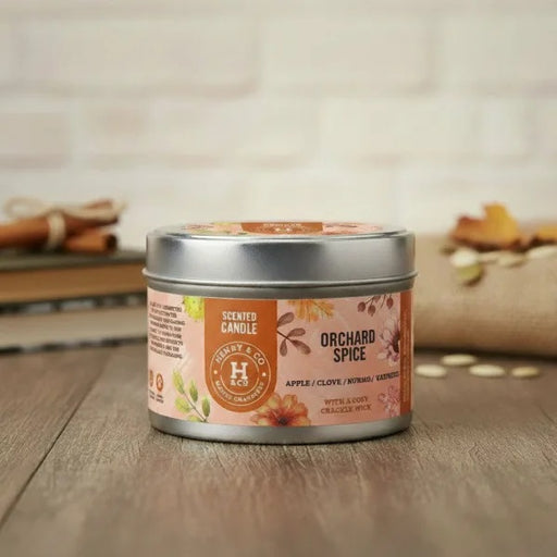 Henry & Co Orchard Spice scented candle 20cl in a silver tin with autumn spice label on a wooden surface