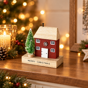 Merry Christmas quirky rust red wooden house decoration with bottle brush trees styled in a warm cosy festive scene with soft golden fairy lights